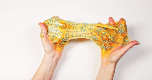 Playing with textured slime with bubbles, stretching the gooey substance for fun