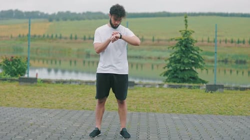 Man Checking Smartwatch After Workout Outdoors