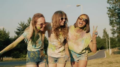 Three happy beautiful women making party at Holi colors festival having fun