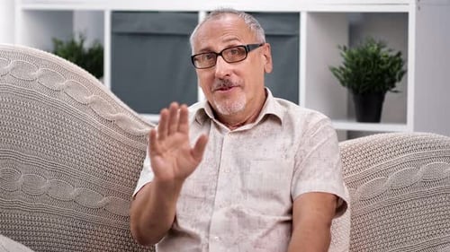 Man Talking and Waving Hand on Couch