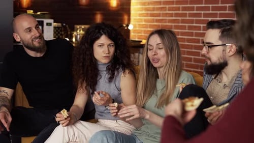 Friends are Sitting on the Sofa Chatting Eating Pizza