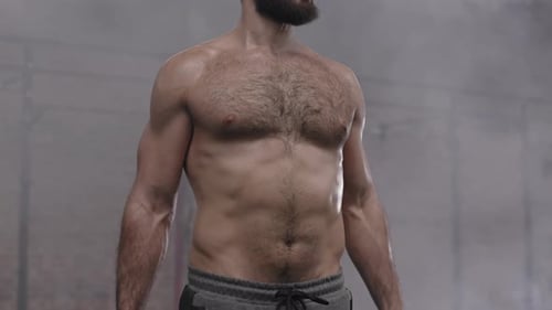 Sportsman Lifting Dumbbells in Gym