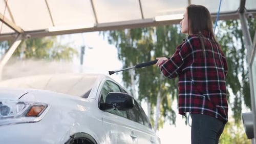 Woman Washing Car with High Pressure Washer