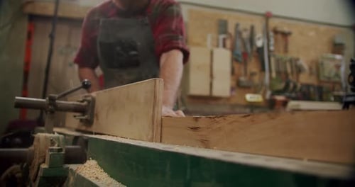 The Master Cuts a Wooden Board with a Circular Saw in the Woodworking Workshop of a Small Furniture