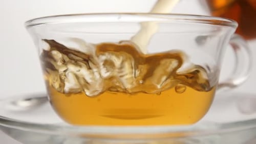 Tea Pouring Into a Clear Glass Cup