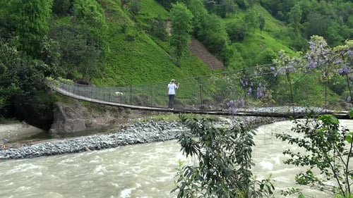 Femme regardant la rivière depuis le pont de corde