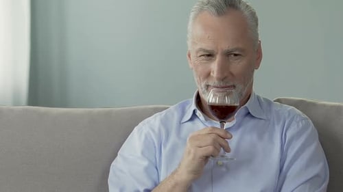 Man Holding Glass of Red Wine on Couch