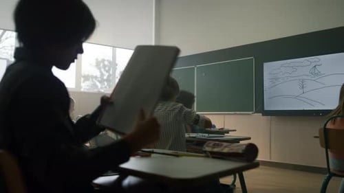 Classroom with Teacher and Students Studying at Desks