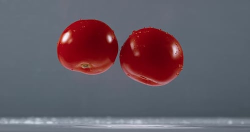 Fresh Tomatoes Dropping Into Water