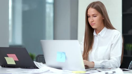 Portrait of Beautiful Pensive Businesswoman Working Using Laptop at Modern Office