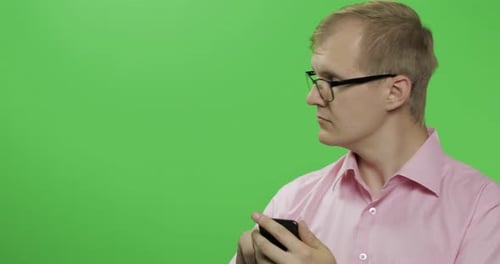 Caucasian Man Scrolling, Texting on the Smartphone. Place for Your Logo or Text