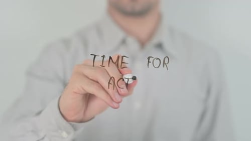 Person Writes Time for Action on Clear Surface