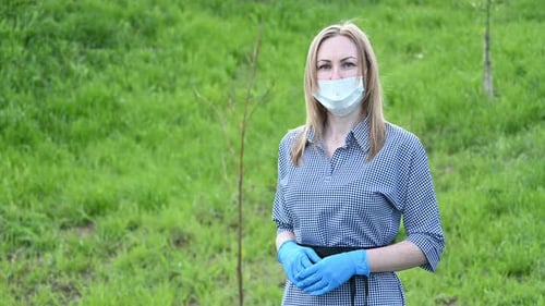 Woman Wearing a Mask Standing in a Field