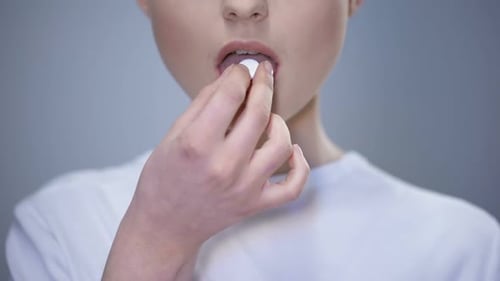 Young Adult Taking Medicine and Drinking Water