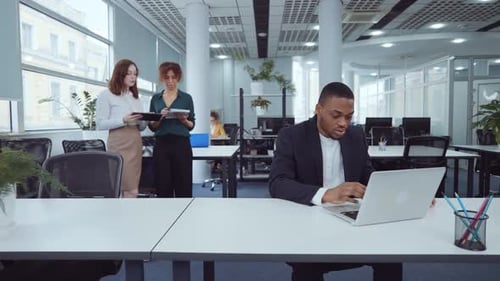 African American Businessman Using Laptop in Open Space Office