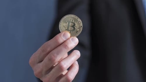 Hand Holding a Gold Bitcoin