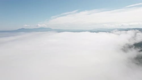 Flying Through the Clouds Above Mountain Tops