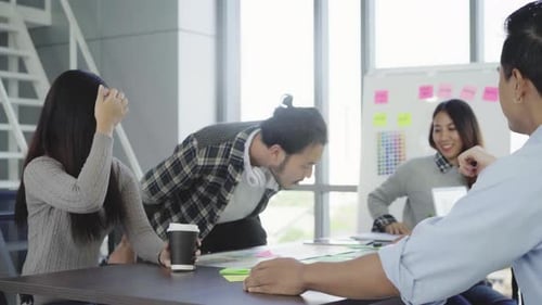 Group of casually dressed businesspeople discussing ideas in the office