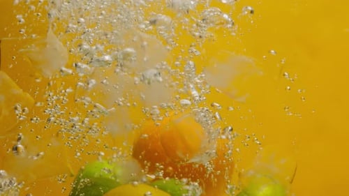 Citrus Fruits Splashing into Clear Water