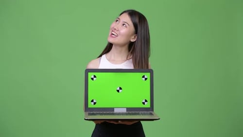 Smiling Young Adult Holding Laptop with Chroma Key Screen