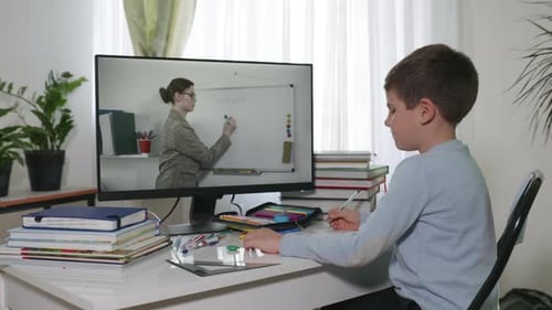 Distance Learning, Homework Boy Watching a Video Broadcast of a Lesson Where a Teacher Explains a