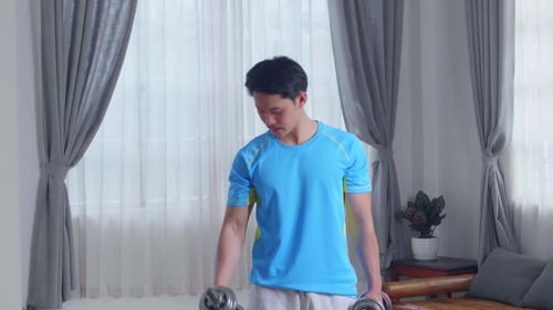 Man Lifting Dumbbells at Home for Fitness