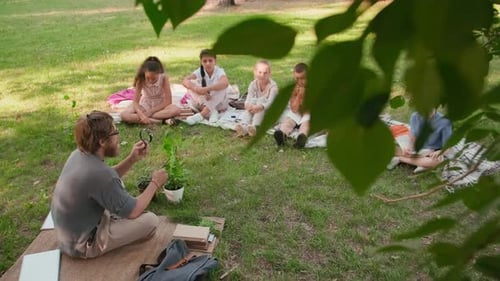 Male Teacher Teaching Kids in Park in Summer