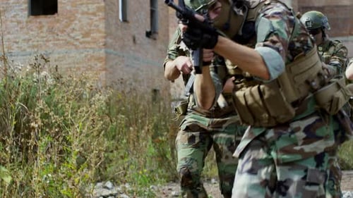 Soldiers Running With Rifles in Urban Ruins