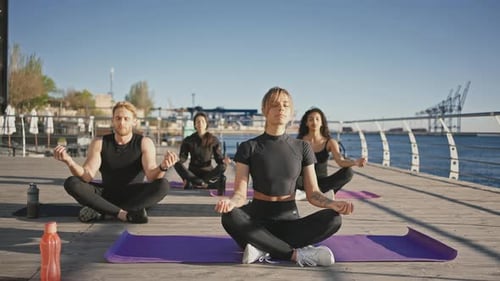 Group Meditating Outdoors in Peaceful Harmony by Ocean