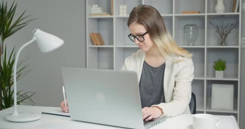 Young Adult Working at Desk with Laptop