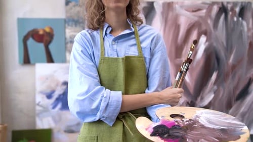 Woman Artist Holding Paints and Paintbrushes