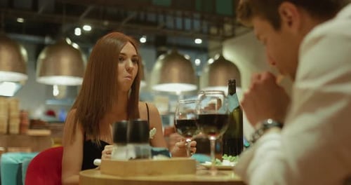 Belle jeune femme dîne dans un restaurant cher avec un homme. Mange une femme heureuse