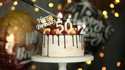 Candles Being Lit on 50th Birthday Cake