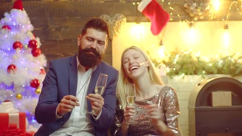 Cheerful Couple Celebrate Christmas with Sparklers and Champagne