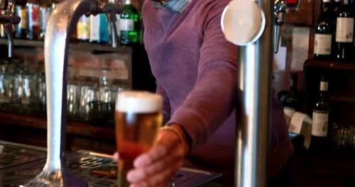 Barman filling beer from beer pump