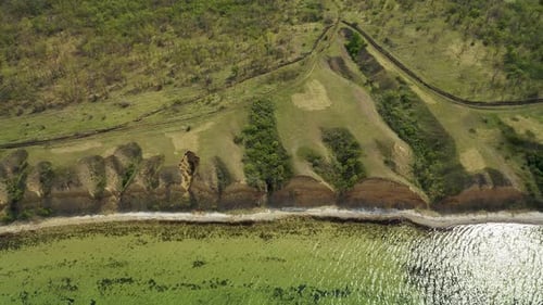 Aerial Drone Footage of Cliffs Along the Shoreline of a Clear Lake