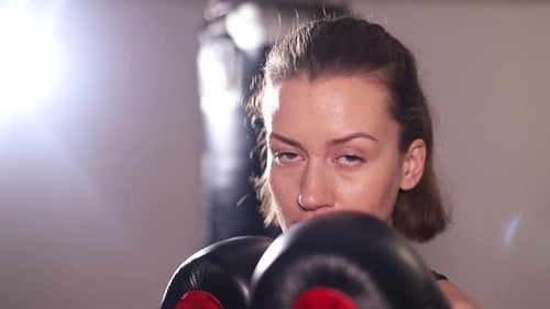 Intense Woman Boxing with Gloves in Gym