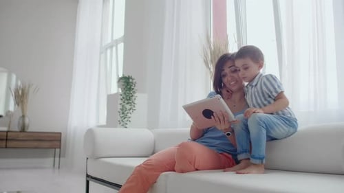 Mother and Child Using Tablet on Couch