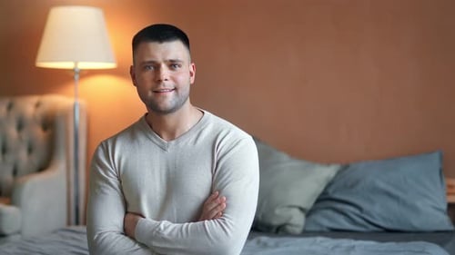 Man Smiling Confidently in Bedroom Setting