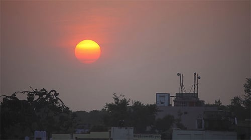 Vibrant Sunrise Above Urban Skyline with Birds