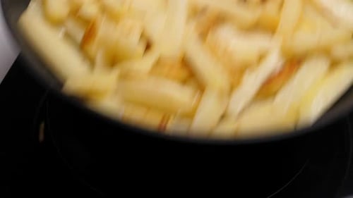 Cooking Fried Potato on Frying Pan. Roasting Sliced Potatoes