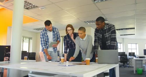 Un joven equipo empresarial mestizo discute sobre gráficos en una oficina moderna 4k