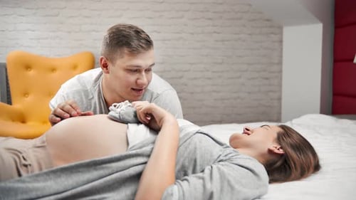 Happy Couple Awaiting New Baby on Bed