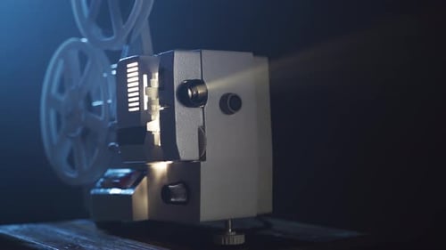 Vintage Film Projector Shining in Dark Room