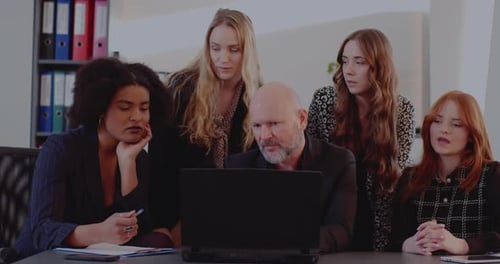 Colleagues Collaborating Around Laptop in Modern Office