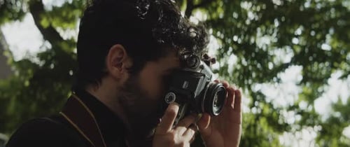 Caucasian man taking pictures in a park