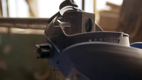 Close Up Footage in Slowmotion of Blue Safety Helmet with Visor and Ear Pieces Hanging on Machine in