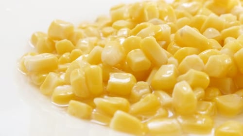 Maize kernels from the can on plate close-up 4K 2160p 30fps UHD footage - Vegetable sweet corn Zea m