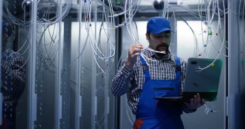 Technician Checking Cables in a Data Center