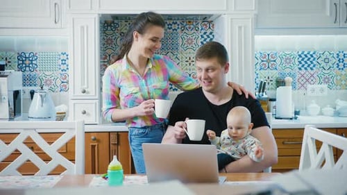 Family with Baby Using Laptop in Kitchen